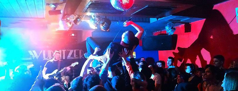 Crowdsurfing sobre el público delante del cartel del Wurlitzer Ballroom